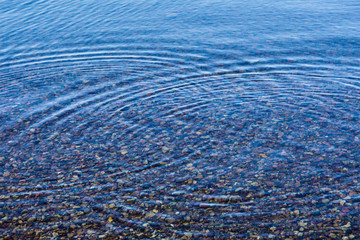 Ripples on sea texture pattern background. Round droplets of water over circles on pool water. Fresh water drop, whirl and splash. Laptop decorative wallpaper. Bright water rings affect the surface.