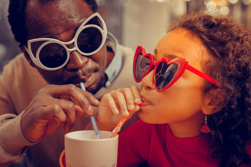 Close up of father and daughter wearing funny sunglasses