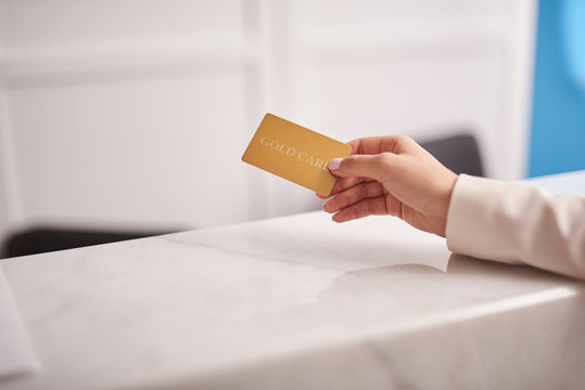Young woman using gold card for payments