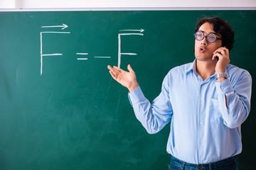 Young male physic standing in front of the green board