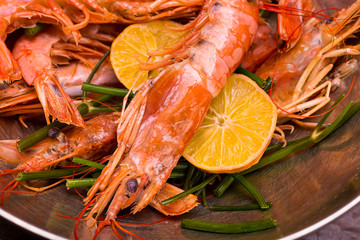 shrimp large pink whole with head and paws and tail against the background of slices of lemon and dill close-up of beer snack