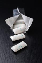Chewing gum on the table. Mint refreshing tablet in a silver package.