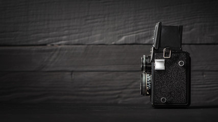 Medium format retro camera, on black. Collection and auctions theme
