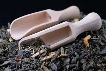 Tea in leaves and wooden whiskers. A blend of the best varieties of tea.