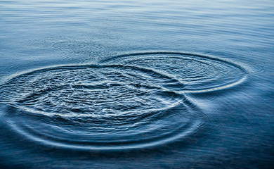 Ripples on sea texture pattern background. Round droplets of water over circles on pool water. Fresh water drop, whirl and splash. Laptop decorative wallpaper. Bright water rings affect the surface.
