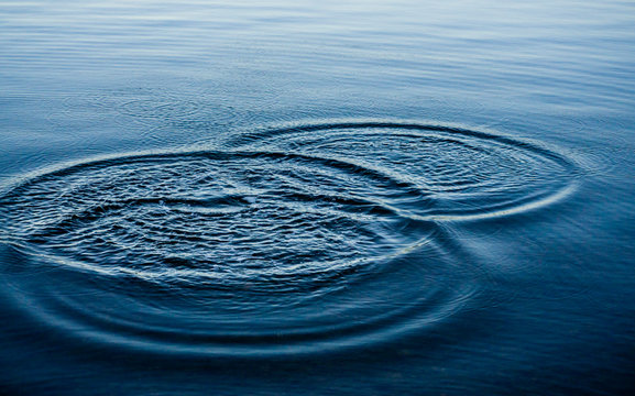 Ripples on sea texture pattern background. Round droplets of water over circles on pool water. Fresh water drop, whirl and splash. Laptop decorative wallpaper. Bright water rings affect the surface.