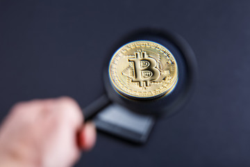 coin bitcoin under a magnifying glass