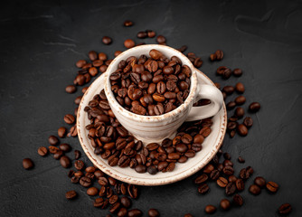 Coffee cup and beans on a concrete table