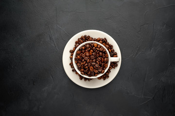Coffee cup and beans on a concrete table