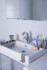 Fototapeta na wymiar New plumbing. Chrome faucet and white sink in the bathroom.