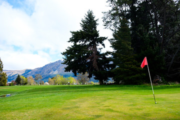 Red flag on golf green in Glenorchy, South Island, New Zealand