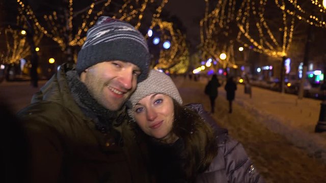 Couple of loving young people is taking photo themselves in the winter city