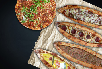 Traditional Turkish pita varieties and Turkish pizza (lahmacun) on black background.