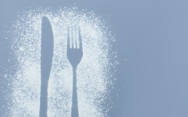  Can use as mockup for design.Top view of cutlery silhouette made with flour and powdered sugar on a gray paper background with space for text. Culinary art, flat lay