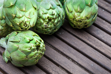 Fototapeta premium Artichokes on wooden table.