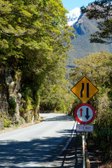 Road narrowing to one way across a bridge in Fjordland National Park, South Island, New Zealand