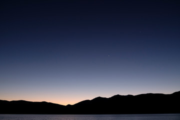 Night view with silhouetted mountains and stars at Lake Te Anau, South Island New Zealand