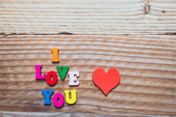 Lettres bois couleur, I love you et coeur rouge sur fond bois vintage