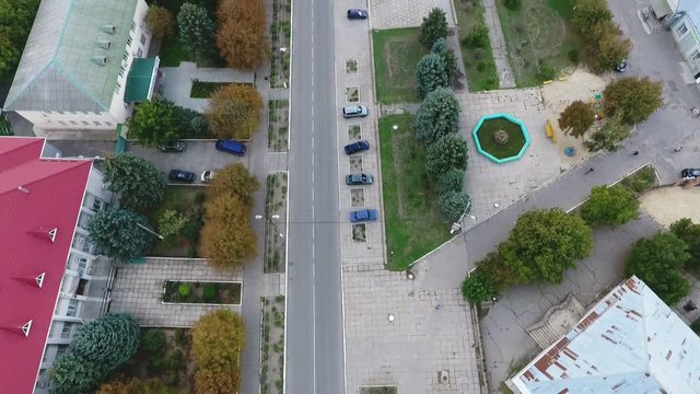 Aerial shot of a highway crossing a town with nice houses and trees in Ukraine   