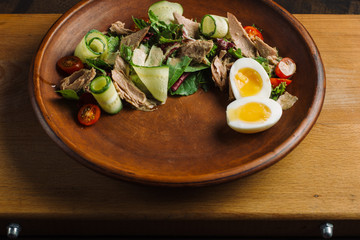 Salad with meat and egg with leaf vegetables, eggs and cherry tomatoes.