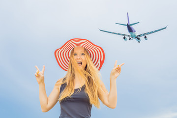 Woman have fun on the beach watching the landing planes. Traveling on an airplane concept