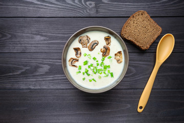 Cheese cream soup on dark wooden background.