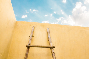wall and blue sky with ladder