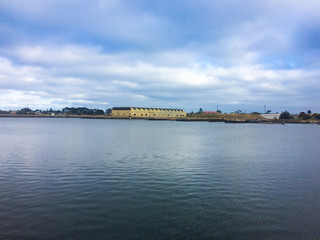 Warehouses and bridge on old port harbor town with blue sea water ocean and blue cloudy sky in summer spring sunset morning