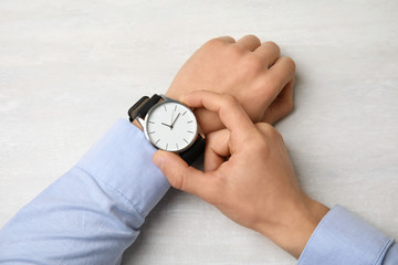 Businessman with stylish wrist watch at table, top view