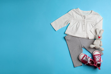 Flat lay composition with clothes and space for text on color background. Baby accessories