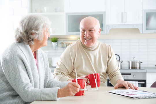 Elderly couple drinking tea at table in kitchen
