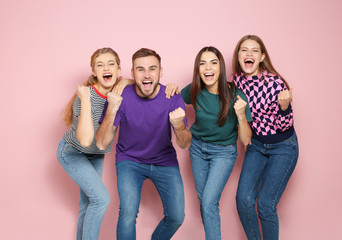 Young people celebrating victory on color background