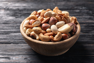 Bowl with organic mixed nuts on wooden table