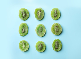 Slices of kiwi on color background, flat lay. Dried fruit as healthy food