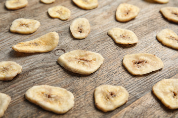 Composition with banana slices on wooden table. Dried fruit as healthy snack
