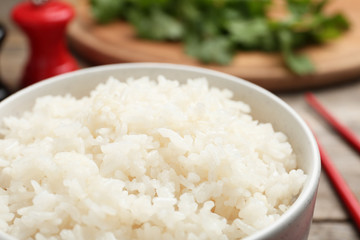 Bowl of boiled rice on table, closeup
