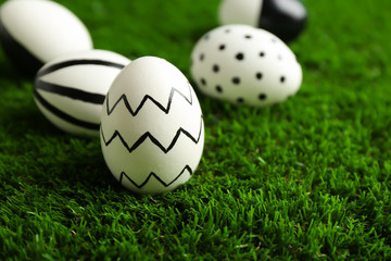 Traditional painted Easter eggs on green lawn, space for text