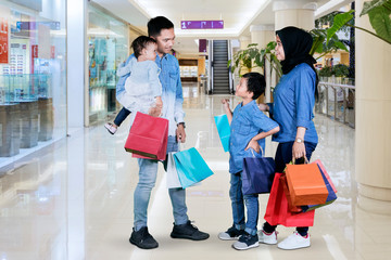 Muslim family with shopping bags in the mall