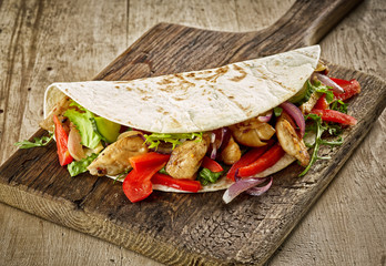Tortilla wrap with fried chicken meat and vegetables