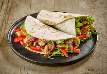 Tortilla wraps with fried chicken meat and vegetables