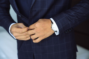 Close-up businessman groom wearing his jacket. Concept of men stylish elegance clothes