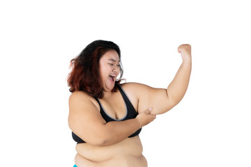 Sad obese woman shows her flabby bicep on studio