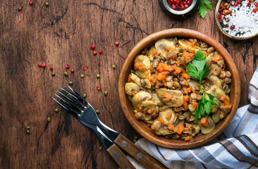 Green lentils with mushrooms and vegetables, vintage wooden kitchen table background, place for text. Vegan or vegetarian meal, clean food concept. Top view