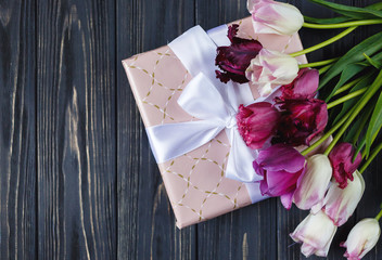 Colorful beautiful pink violet tulips and gift box on gray wooden table. Valentines, spring background. floral mock up.  with copyspace. happy mothers day, romantic still life, fresh flowers