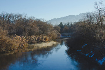 The cold steam rolling of the creek in the winter parkland area. 