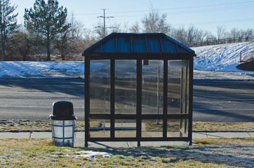 The empty glass bus stop hut on the cold morning streets. 