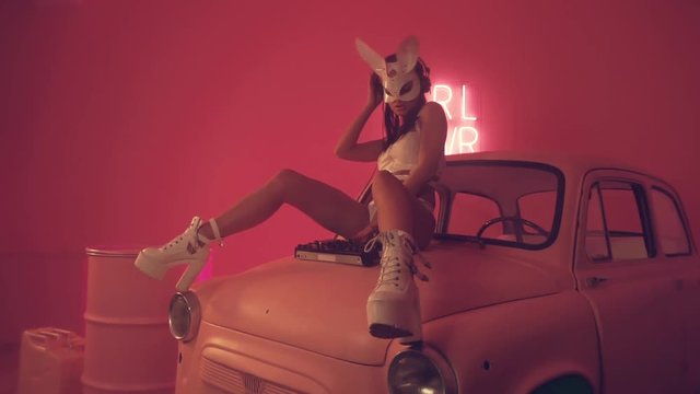 Sexy woman DJ playing on pink car