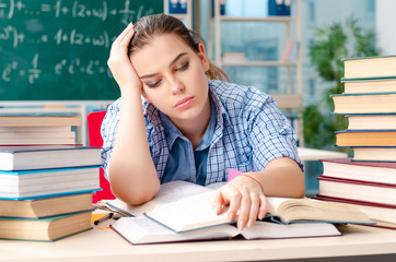 Female student with many books sitting in the classroom