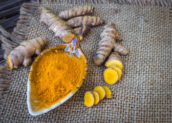 Obraz premium Turmeric powder and turmeric on old wooden background, Herbal