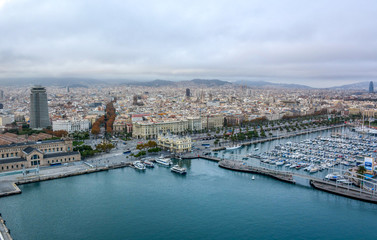 Aerial view over historical city center of Barcelona Spain with La Rambla main street, square Portal de la pau, Port Vell marina and Columbus Monument after sunset.